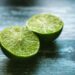 Vibrant green lime halves on a rustic wooden surface, showcasing fresh citrus texture.