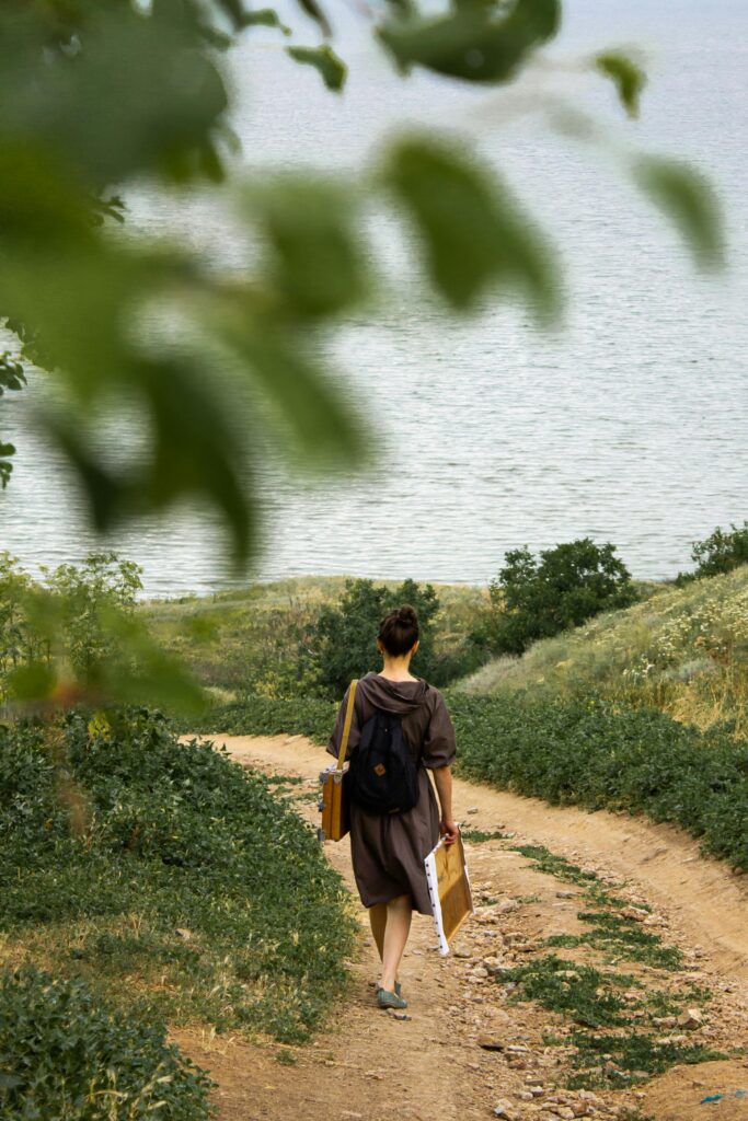 pexels-photo-4729074-4729074 Full body back view of unrecognizable painter with backpack and equipment for drawing walking along path to pond