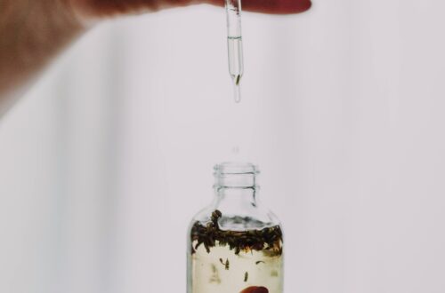 Close-up of hands using a dropper with an essential oil bottle, perfect for wellness themes.