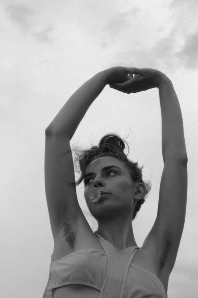 Artistic black and white image of a woman with arms raised, symbolizing empowerment.